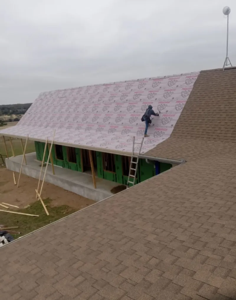 Worker preparing underlayment for a metal roof installation in Vancouver